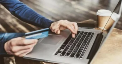 Pessoa utilizando cartão de crédito e laptop para compras online, ilustrando o cenário do Varejo queda janeiro 2026 Índice Stone.