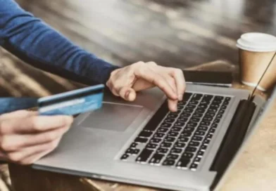 Pessoa utilizando cartão de crédito e laptop para compras online, ilustrando o cenário do Varejo queda janeiro 2026 Índice Stone.